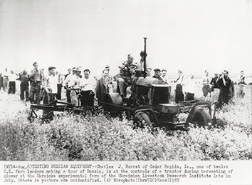 1955, July. BA. Kharkiv Region, Soviet Ukraine. TESTING RUSSIAN EQUIPMENT. Charles J. Hearst of Cedar Rapids, Ia, one of twelve U.S. farm leaders visiting USSR, is at the controls of a tractor during harvesting of clover at the Ukrainka experimental farm of the Ukrainian Livestock Research Institute. AP Wirephoto (Front)