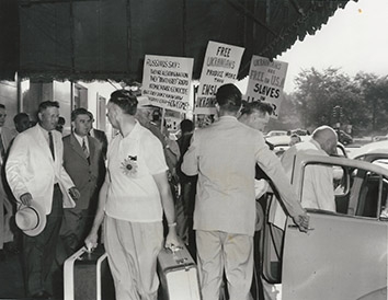 1955, August 13. GA. Chicago, Illinois. SOVIET FARM GROUP PICKETED. Soviet farmer group picketed by immigrants from Estonia, Lithuania, Ukraine and Baltic region. Vladimir Matskevich, Soviet farm chief, entering cab at extreme right. AP Photo (Front)